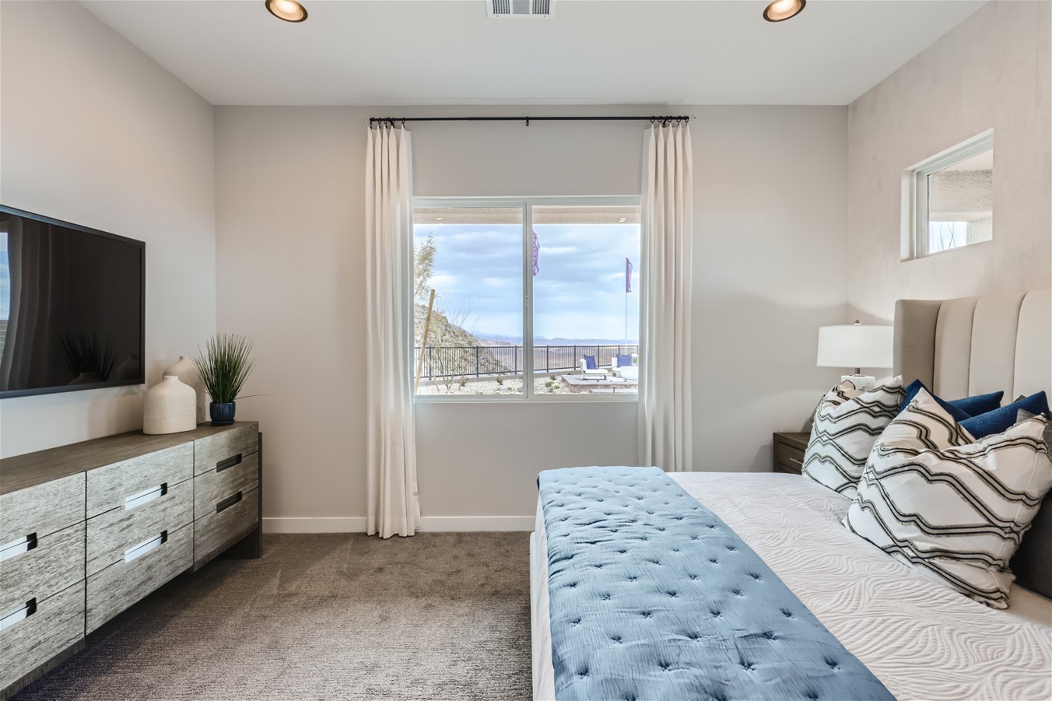 A bedroom with a large window.