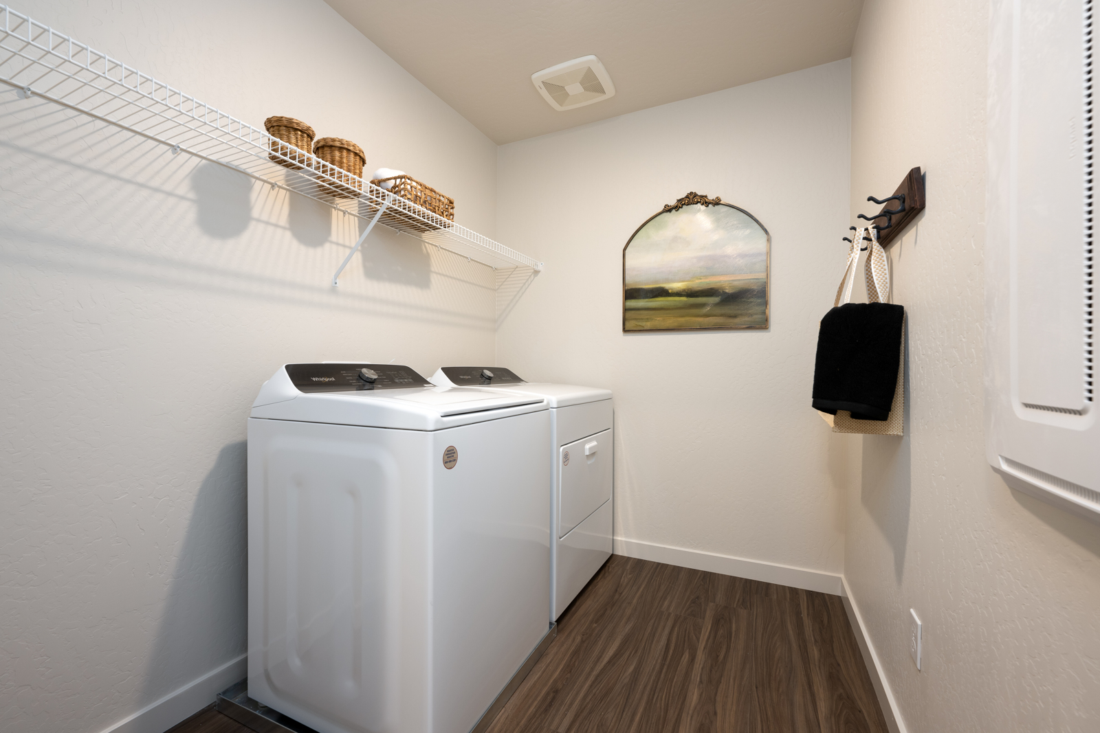 A laundry room with a mirror and a shelf.