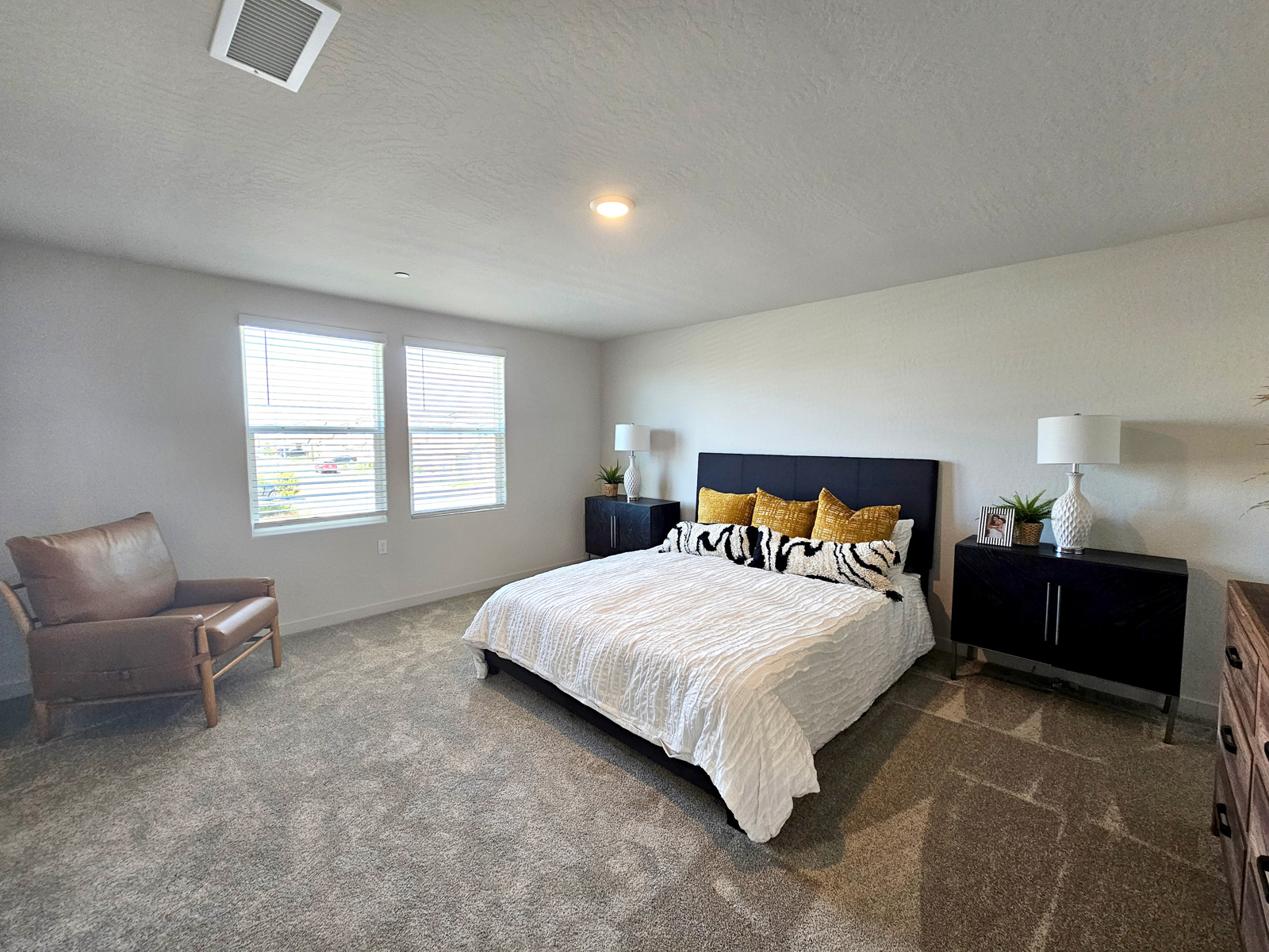 A bedroom with a bed and a chair.