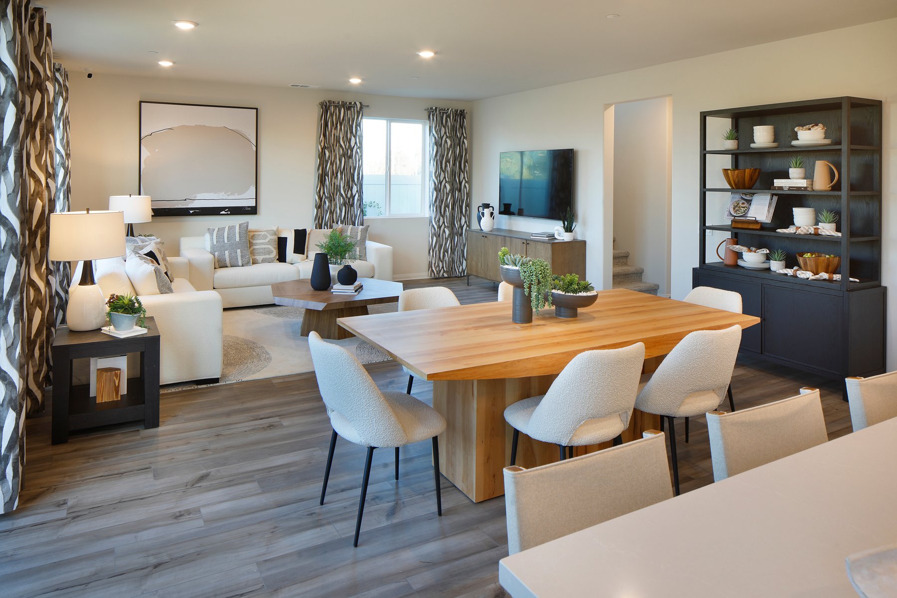 A large living room with a large table and chairs.