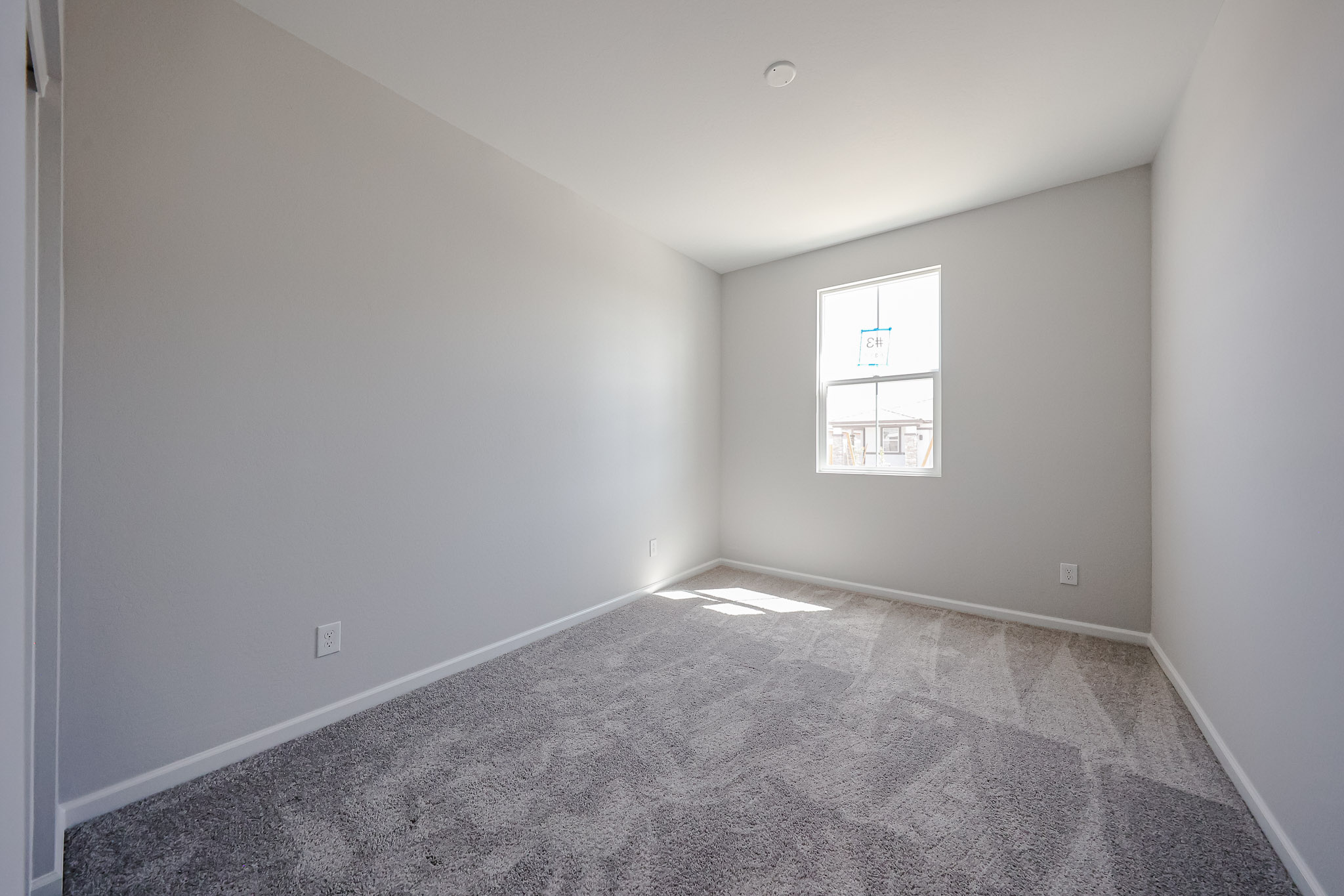 A room with a carpet and a window.