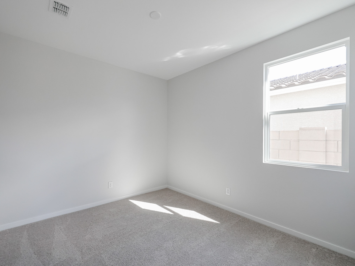 A room with a window and a carpet.