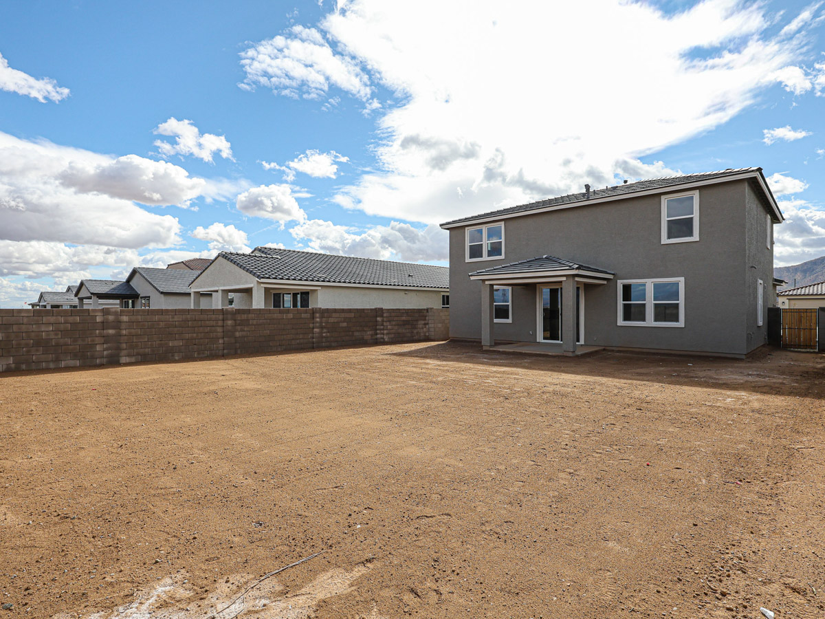 A dirt road leading to a house.