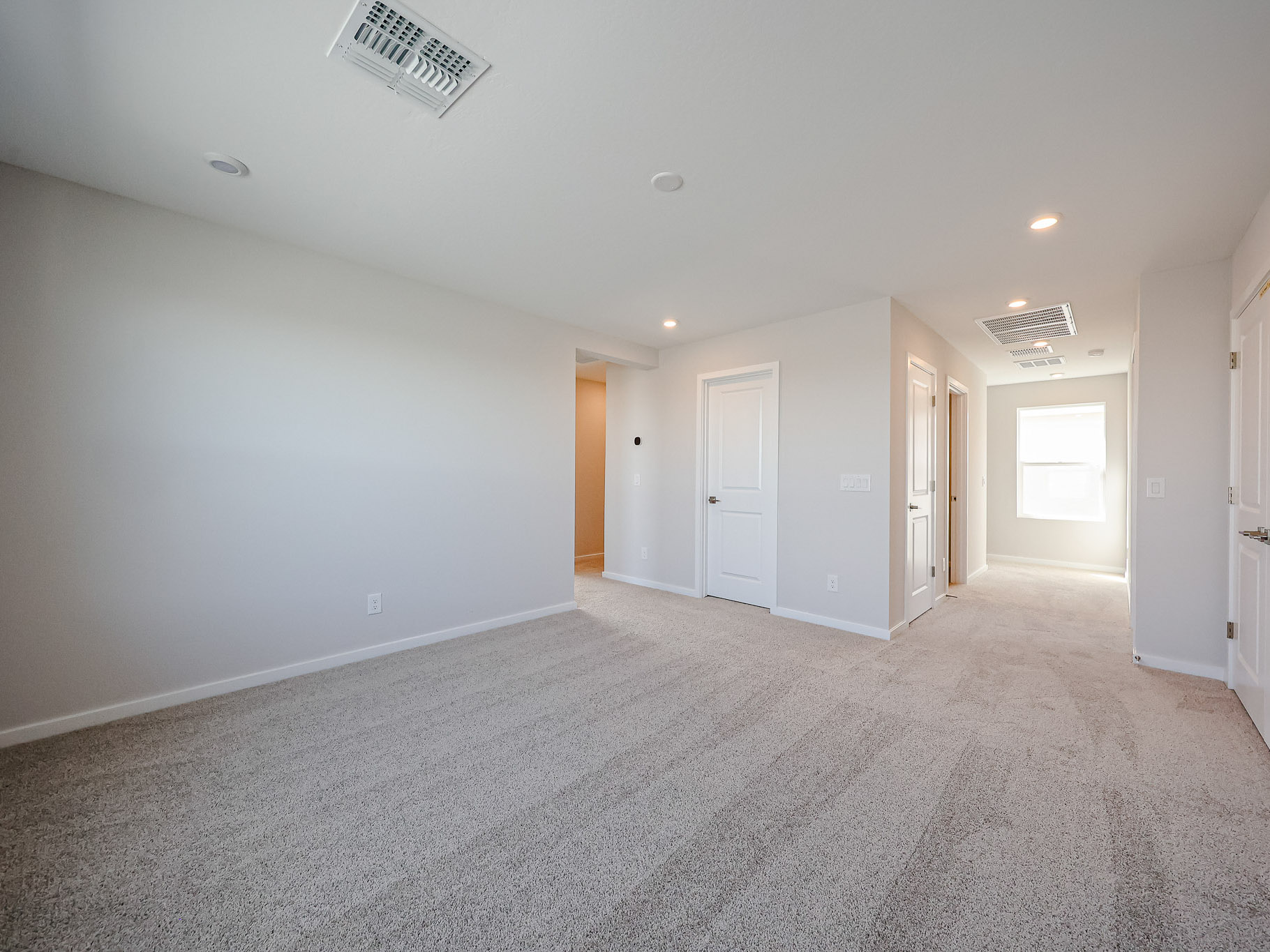 A long hallway with white doors.
