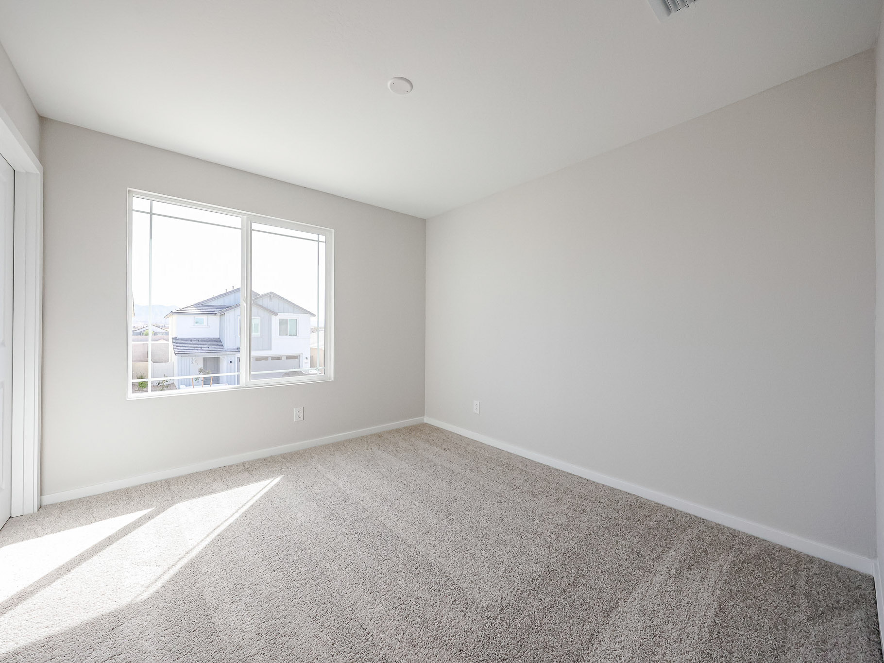 A room with a carpet and a window.