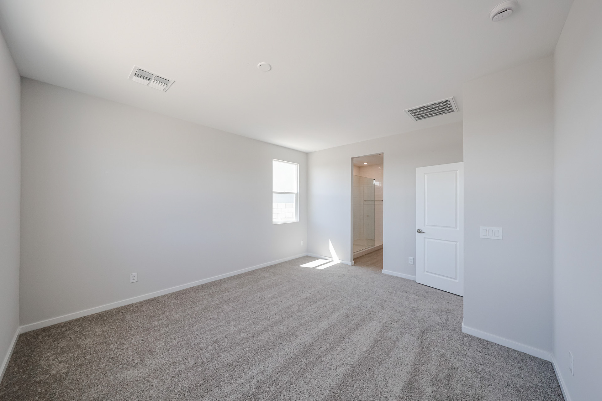 A room with a carpet and a door.