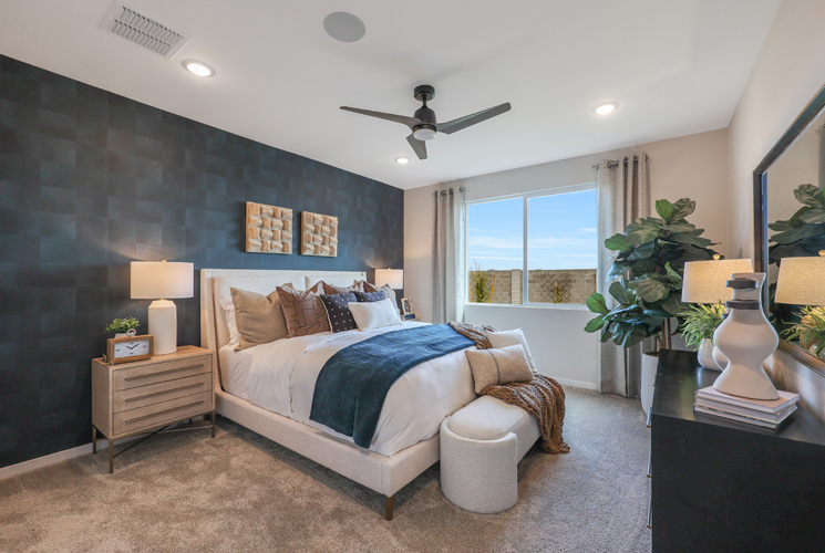 A bedroom with a large bed and a fan.