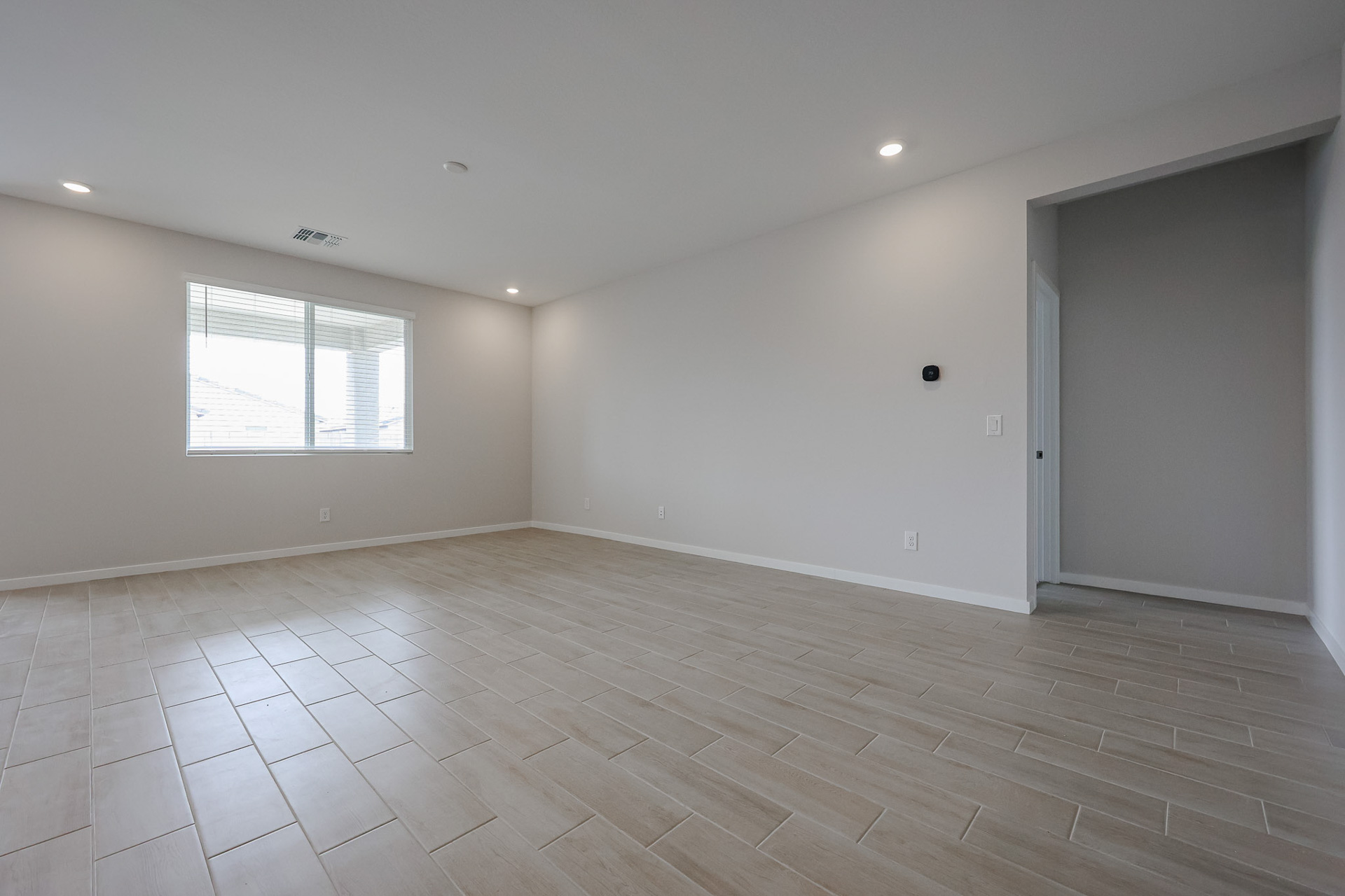 A room with a wood floor and a window.