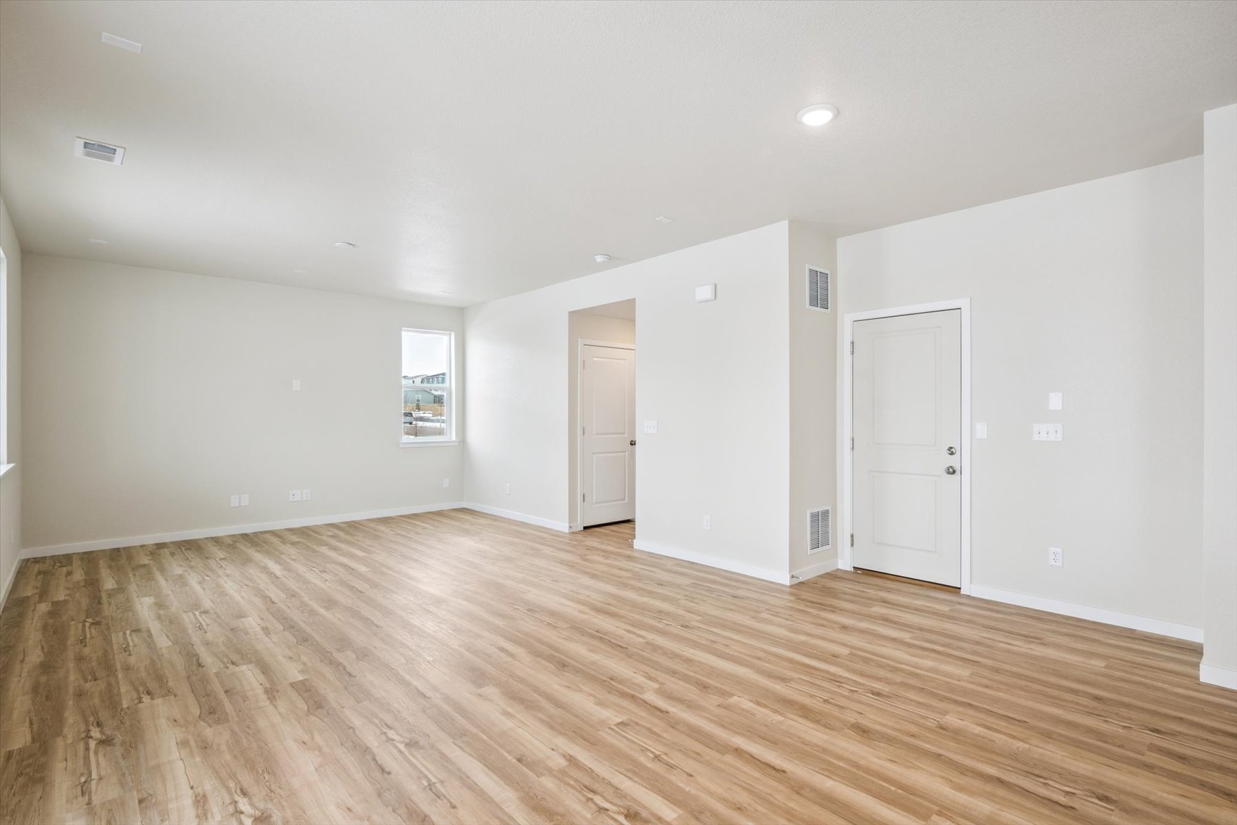 A room with white walls and wood floors.
