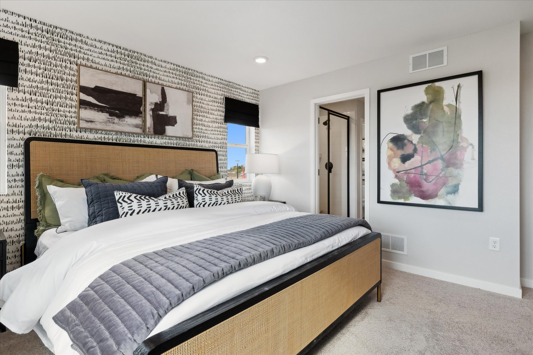 A bedroom with a bed and a painting on the wall.