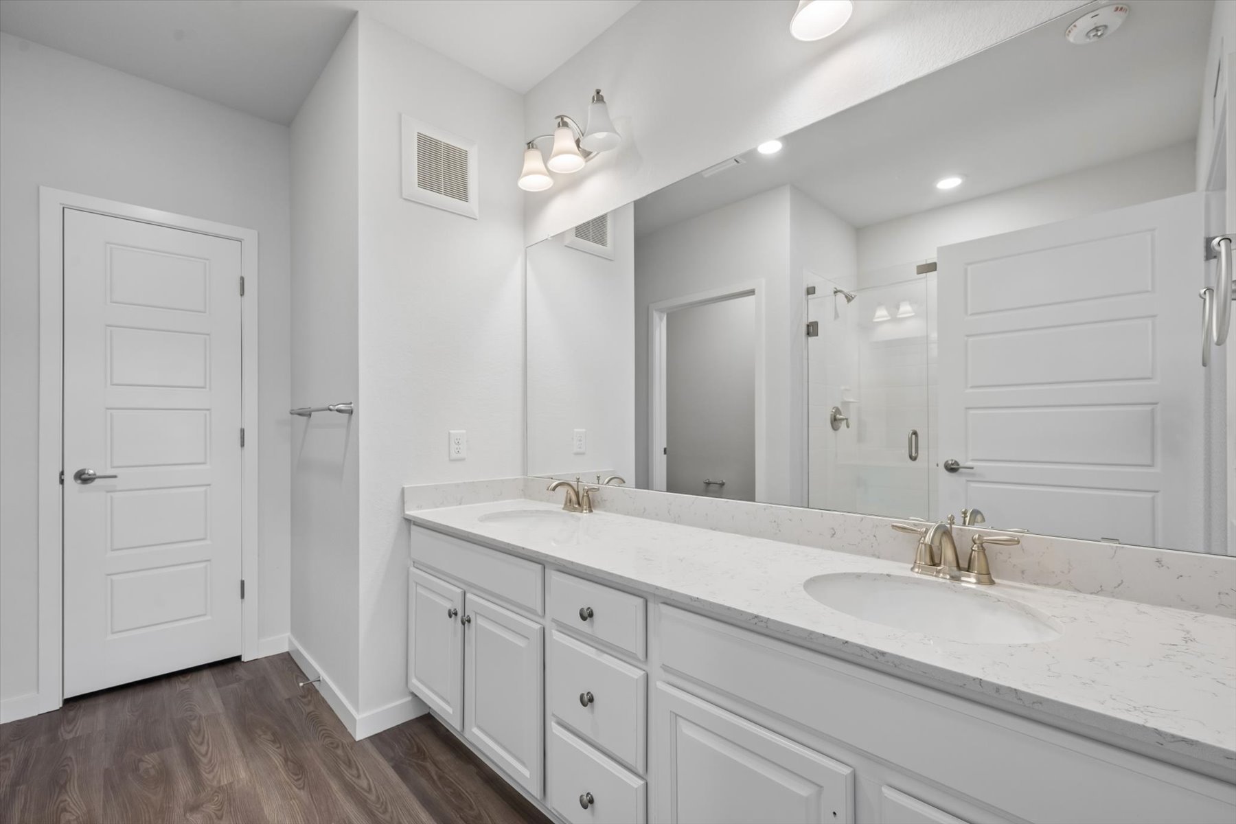 A bathroom with white cabinets.