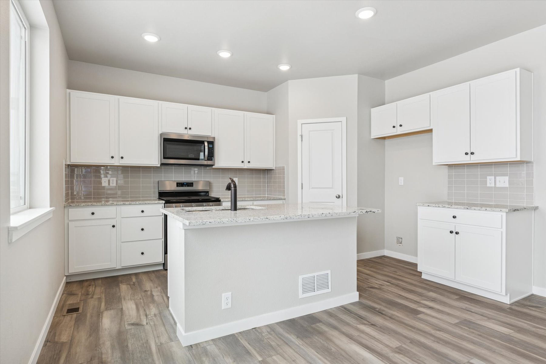 A kitchen with white cabinets.