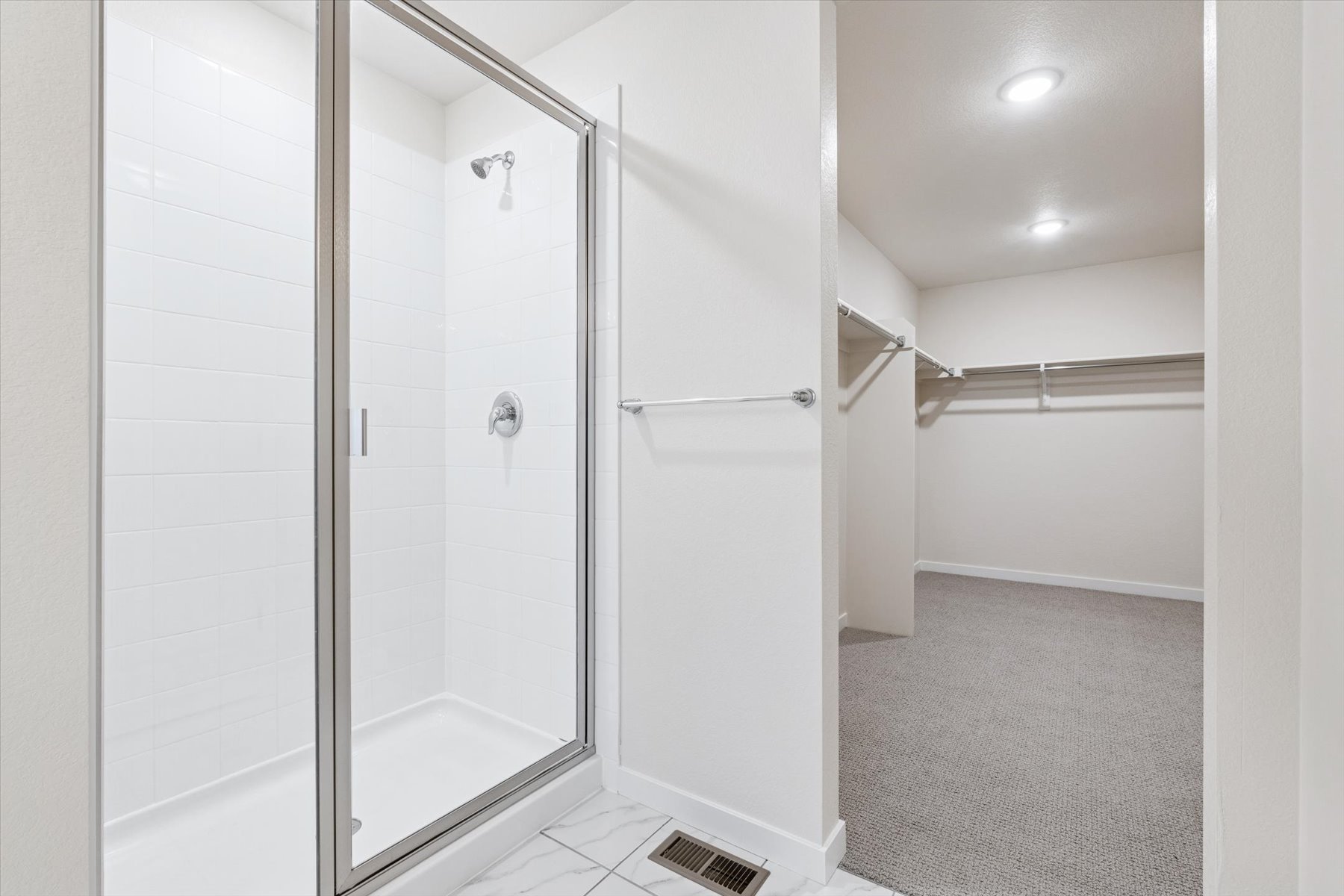 A bathroom with a shower unit and a bathtub.