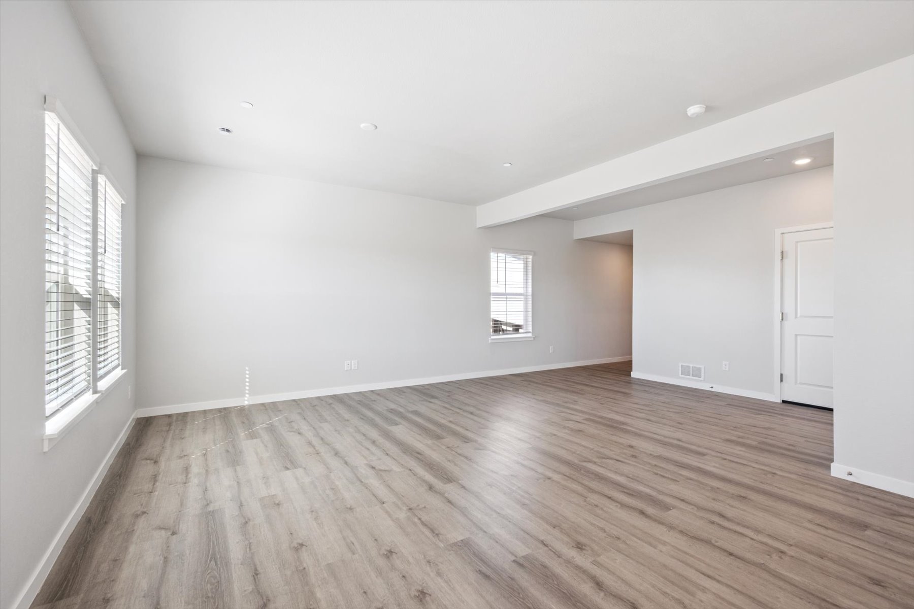 A room with a wood floor and windows.