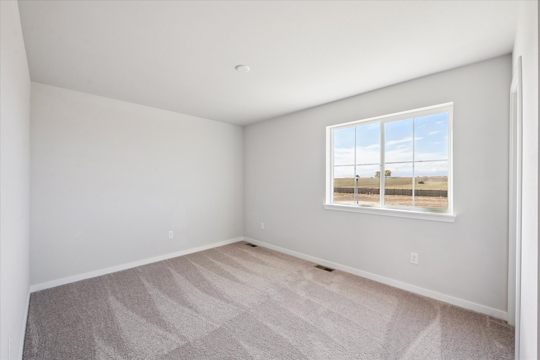 A room with a window and carpet.