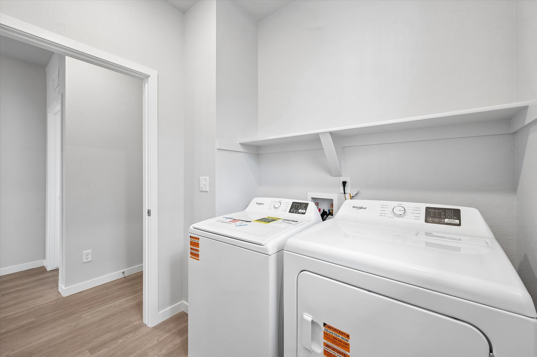 A white laundry room with a white laundry machine.