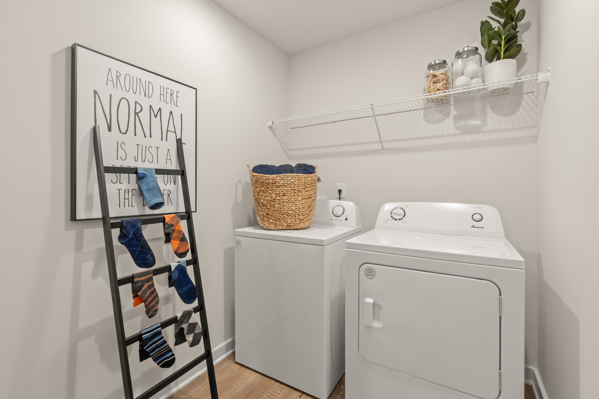 A laundry room with a white laundry basket and a white laundry basket.