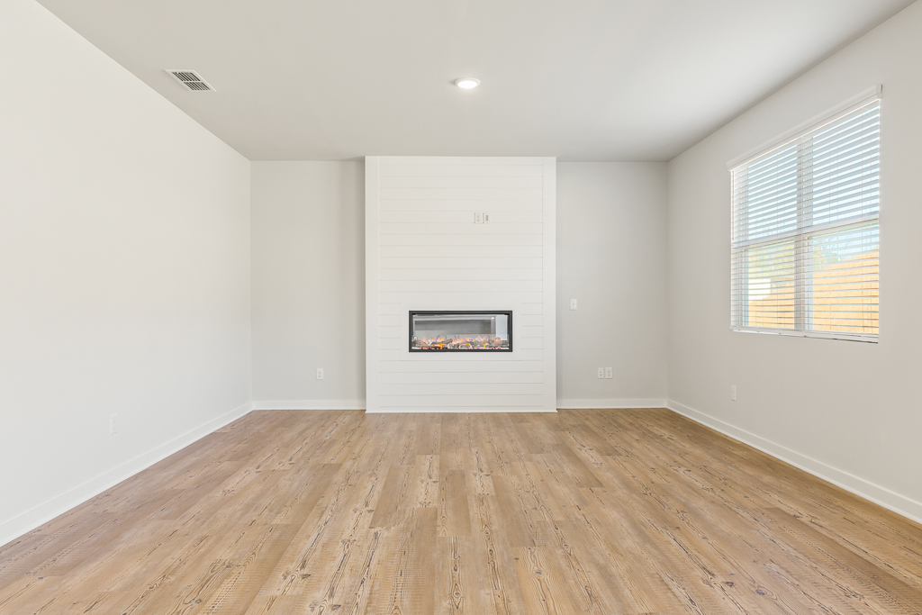 A room with a wood floor and a painting on the wall.
