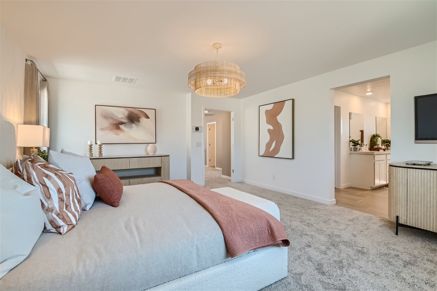 A bedroom with a bed and a chandelier.