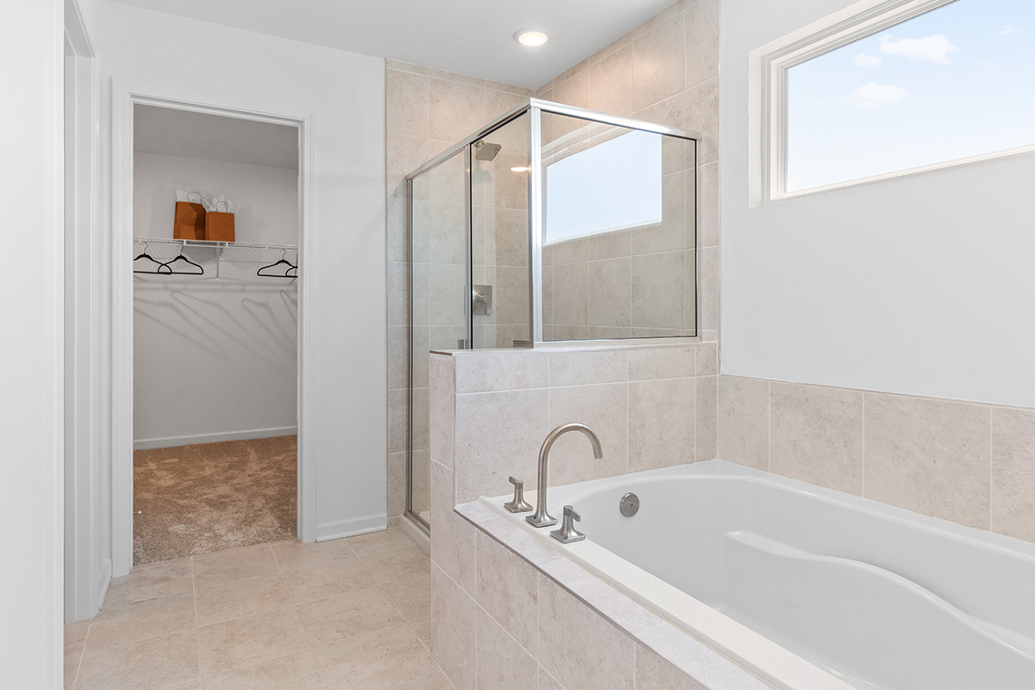 A bathroom with a tub and a mirror.
