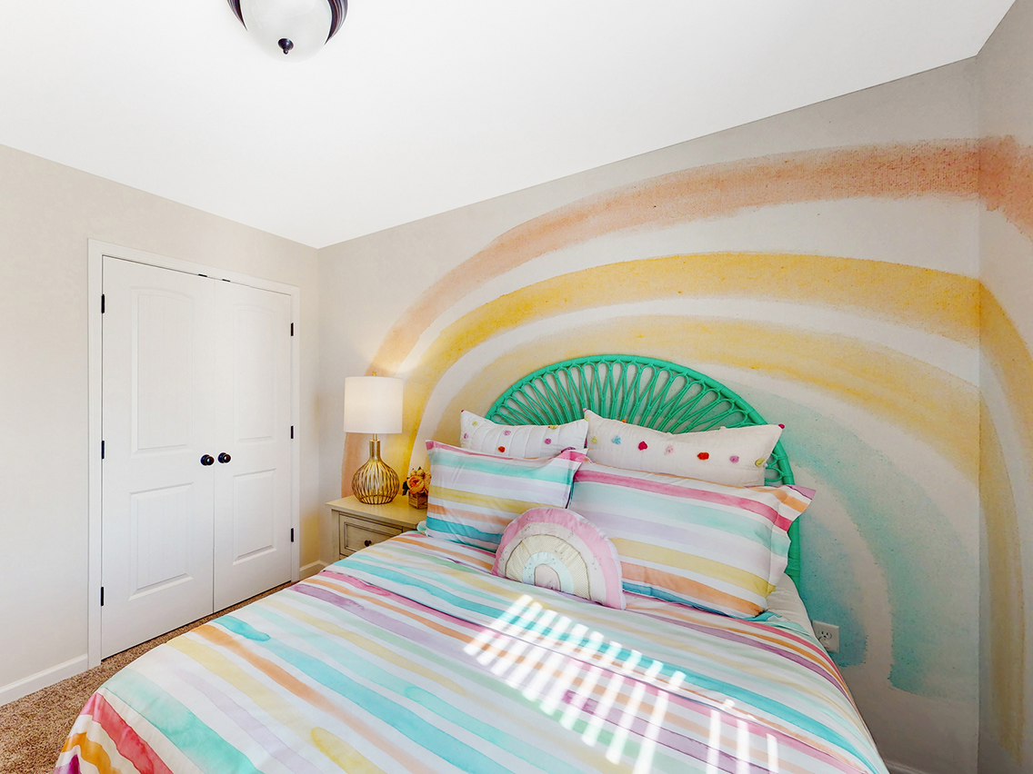 A bed with a colorful bed spread.