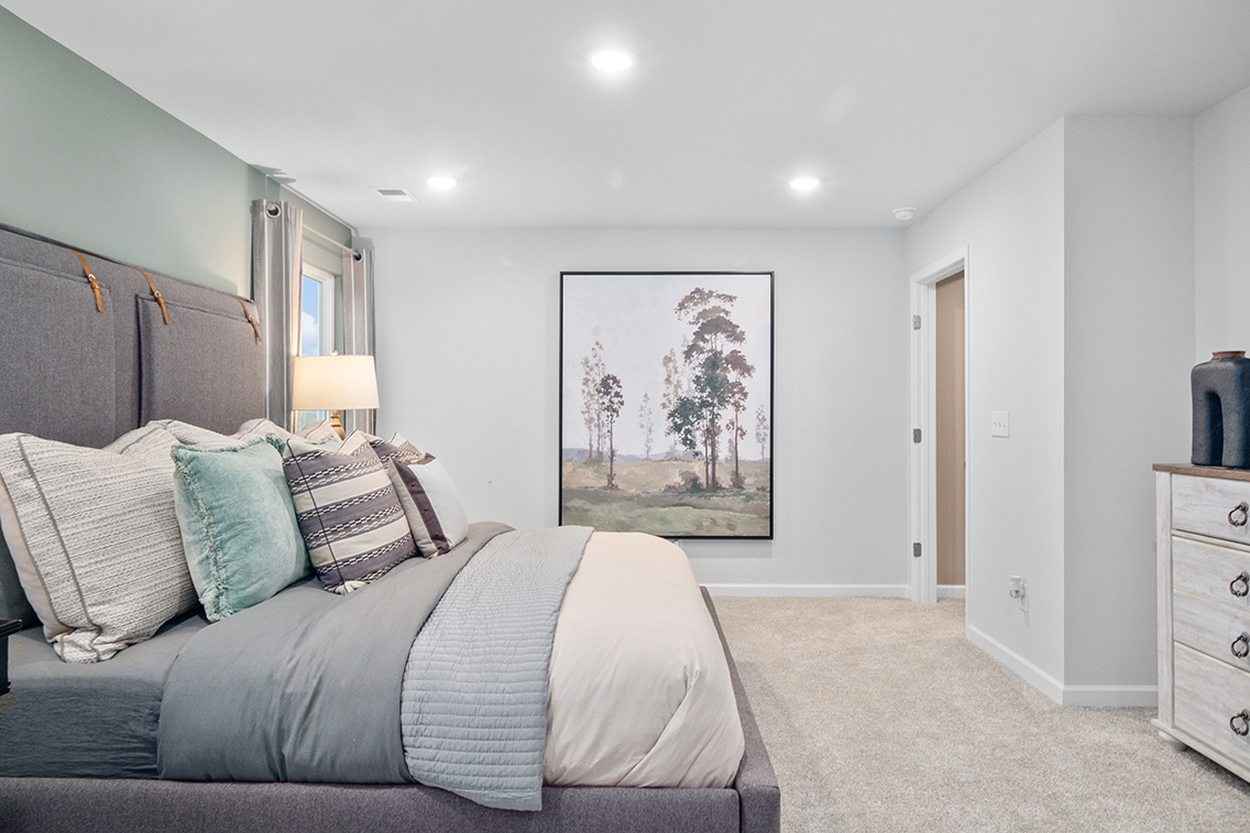 A bedroom with a large painting on the wall.