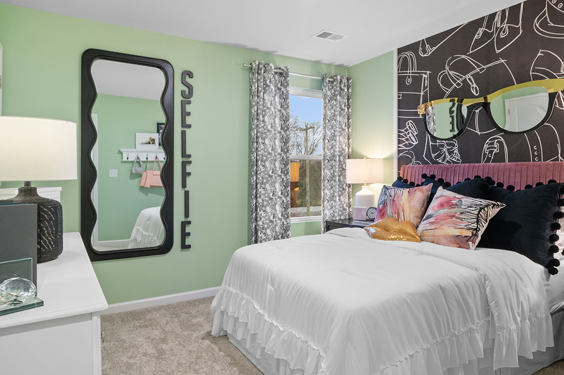 A bedroom with a large mirror.