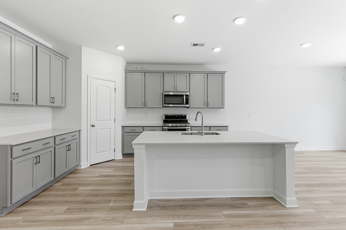 A kitchen with white cabinets.