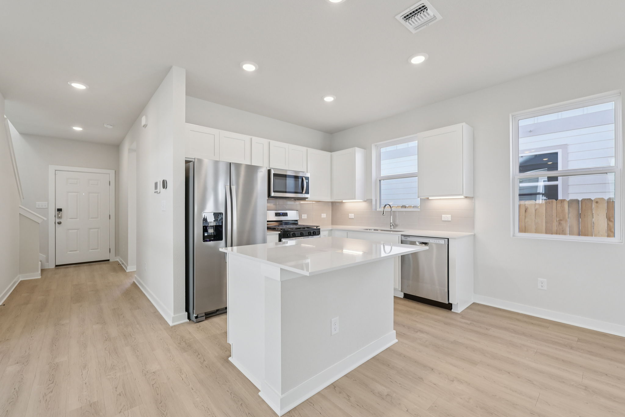 A kitchen with white cabinets.