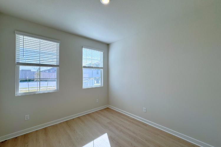 A room with windows and wood floor.