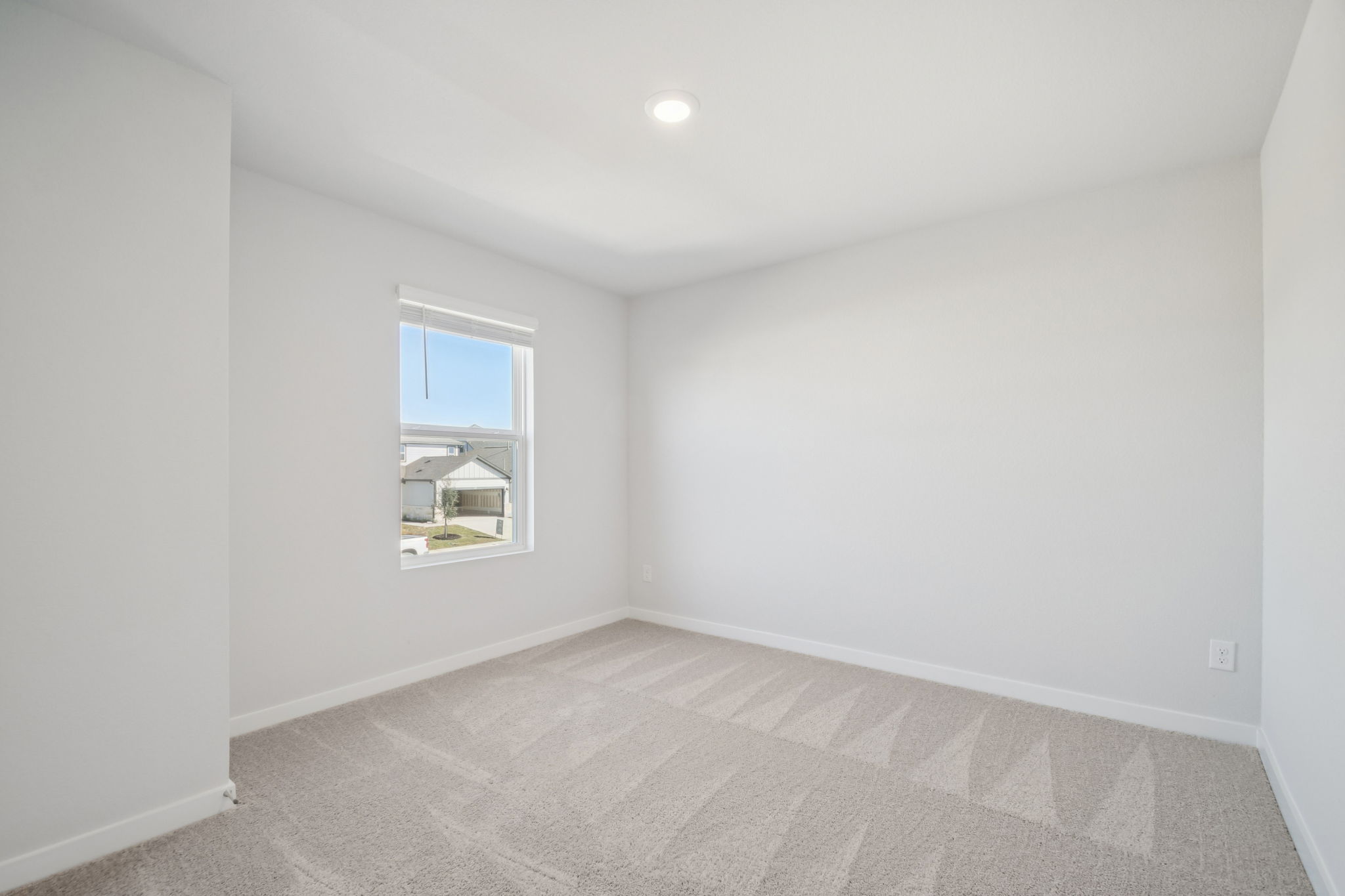 A room with a carpet and a window.