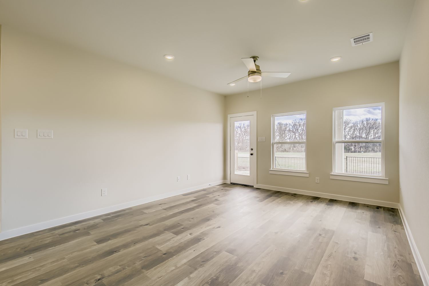 A room with a wood floor and a ceiling fan.
