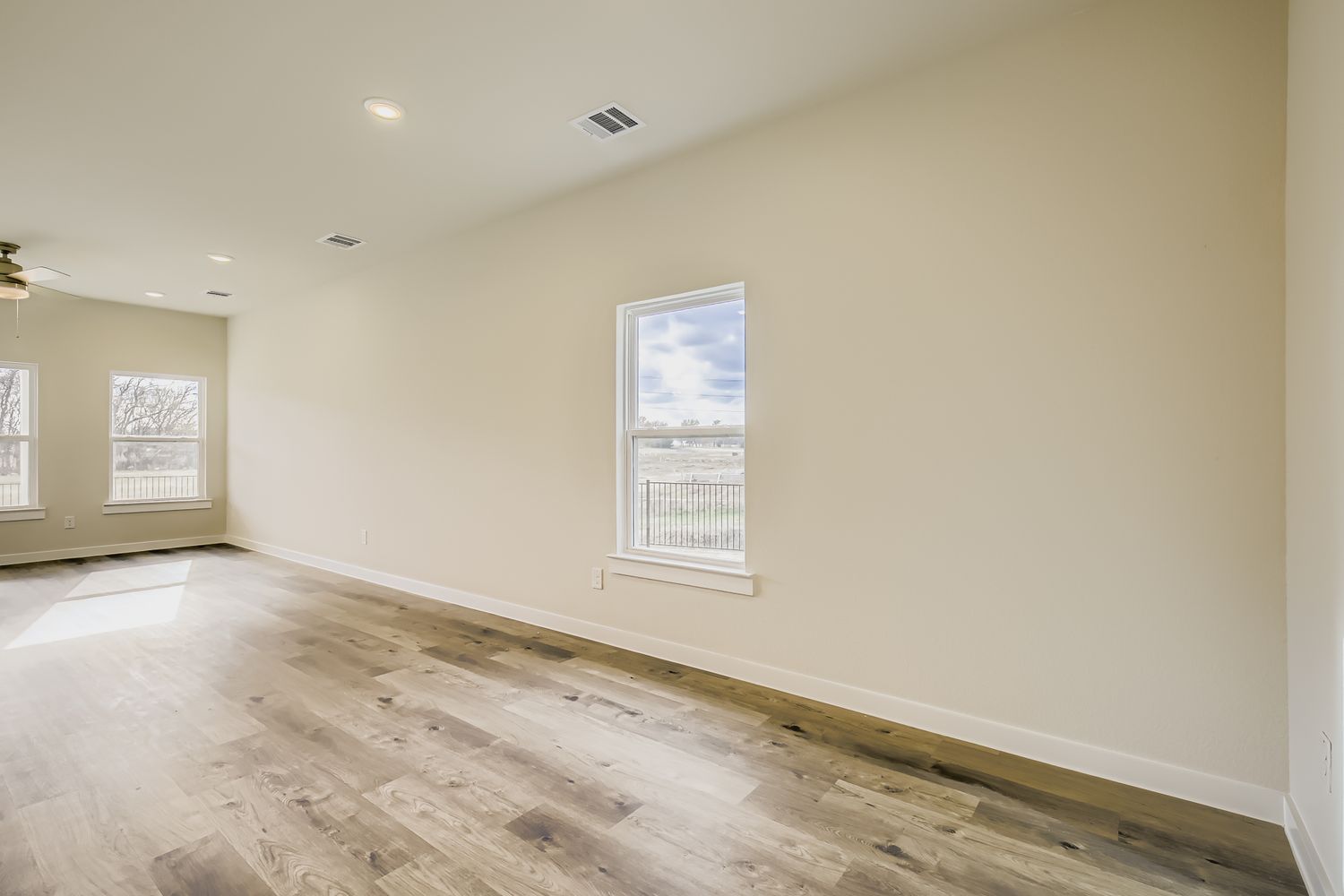 A room with a wood floor and a window.