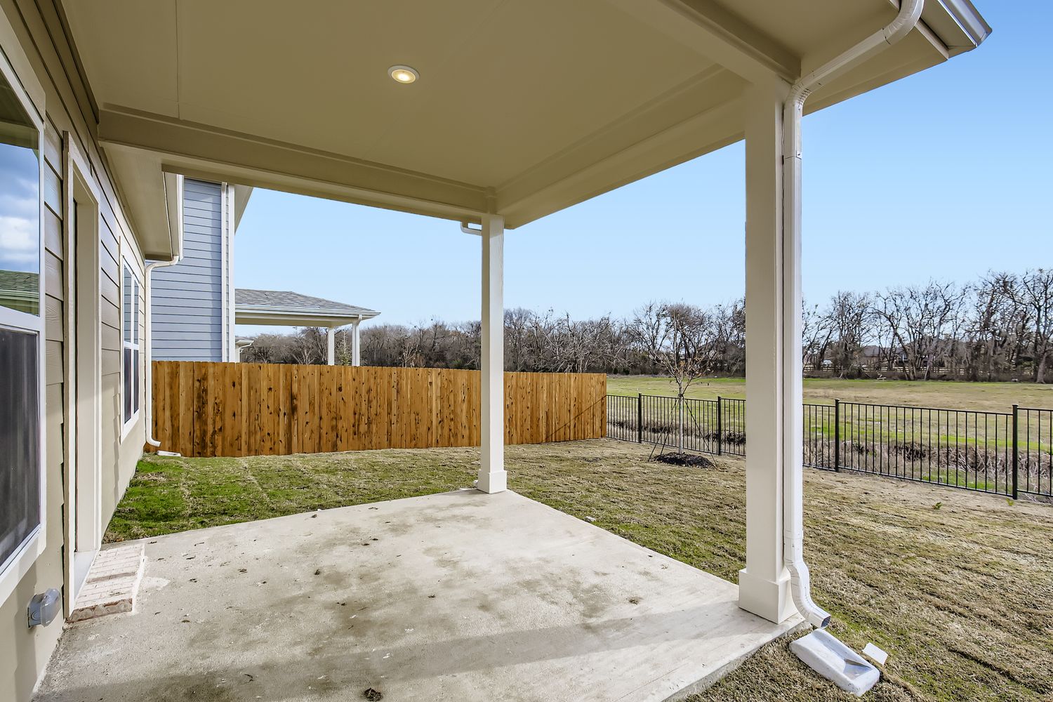 A house with a fence and a yard with a wood fence.