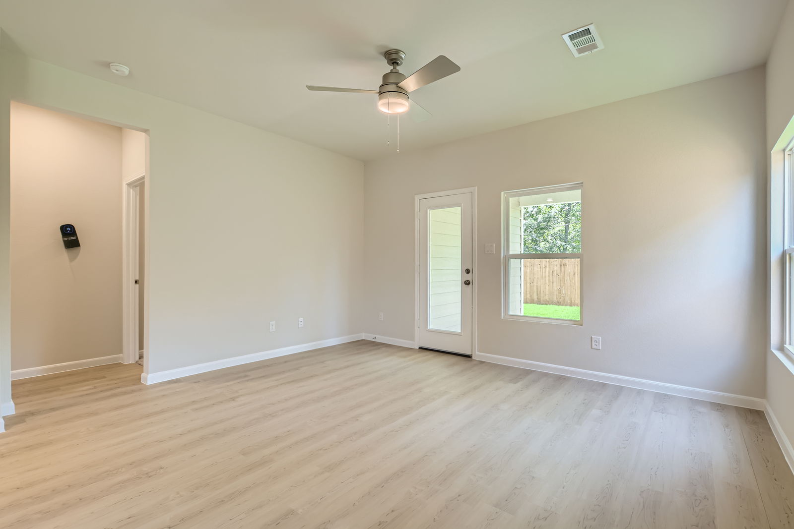 A room with a wood floor and a ceiling fan.