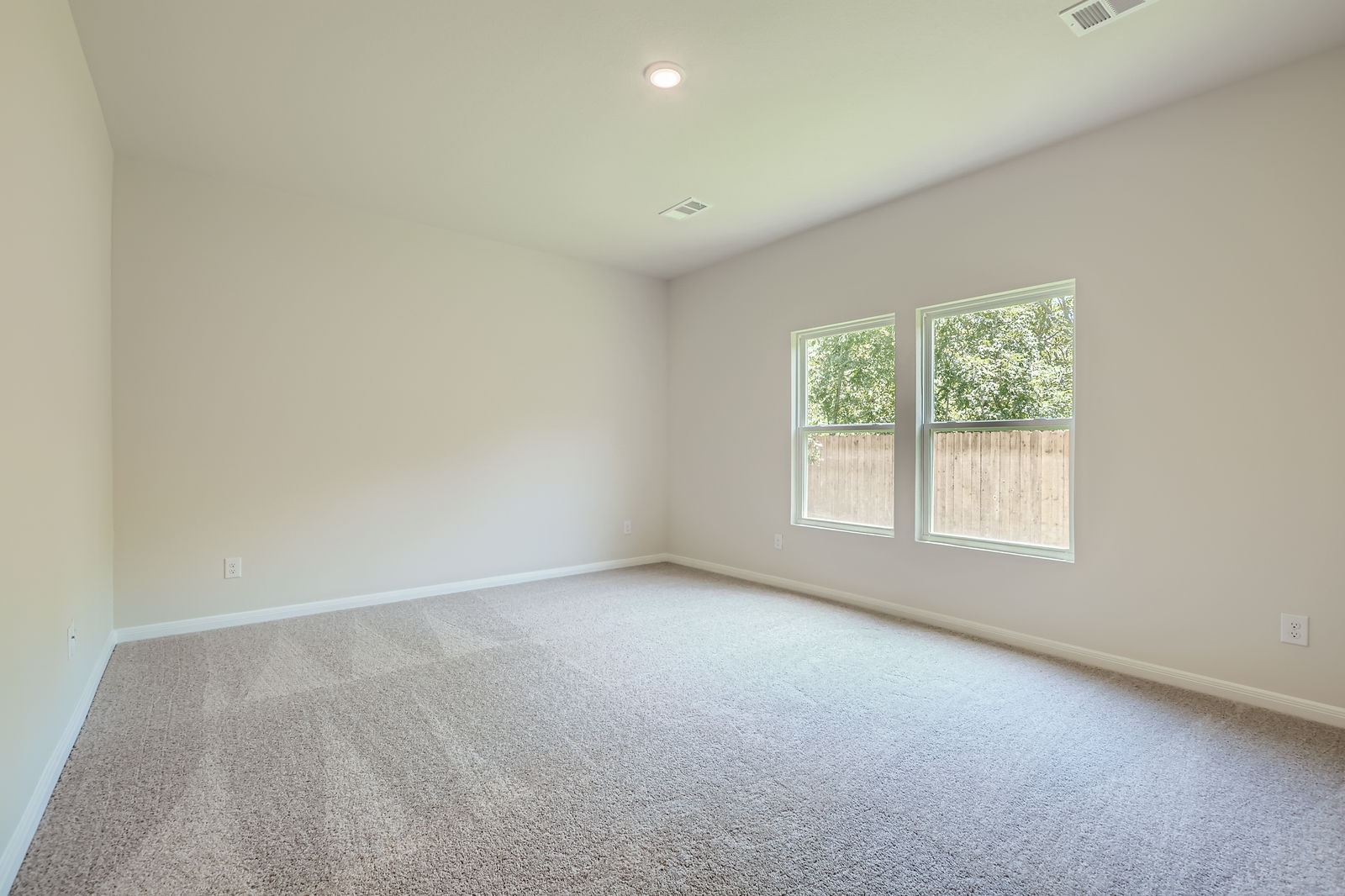 A room with a carpet and windows.