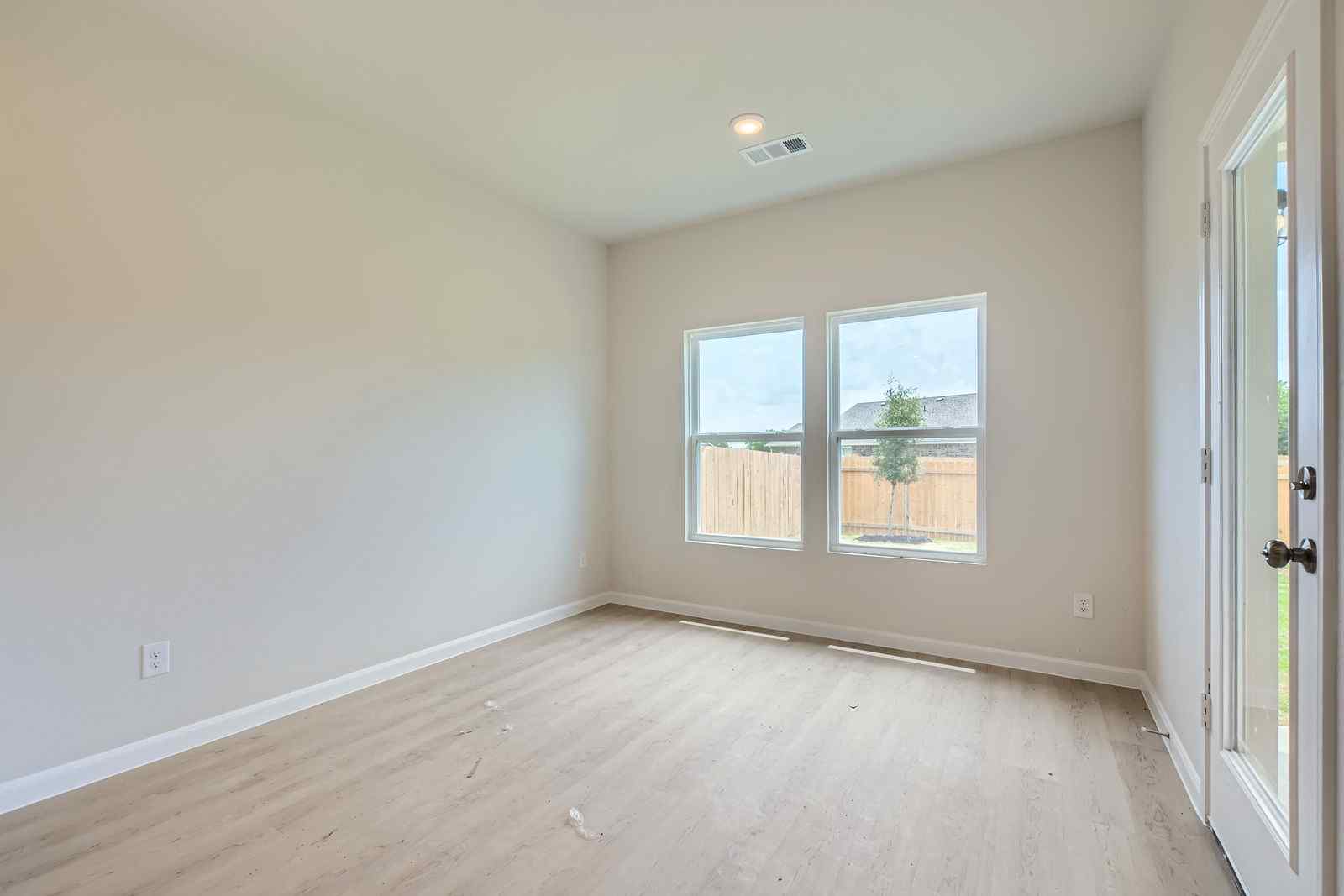 A room with a wood floor and windows.