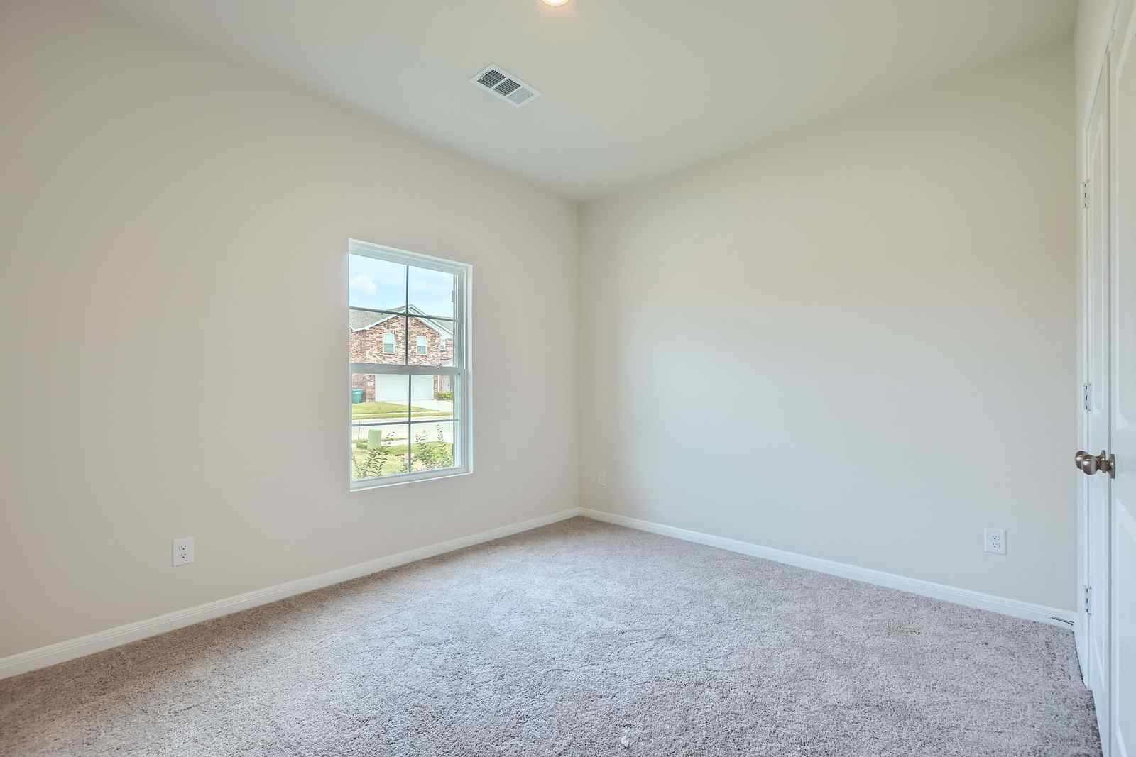 A room with a window and a carpet.