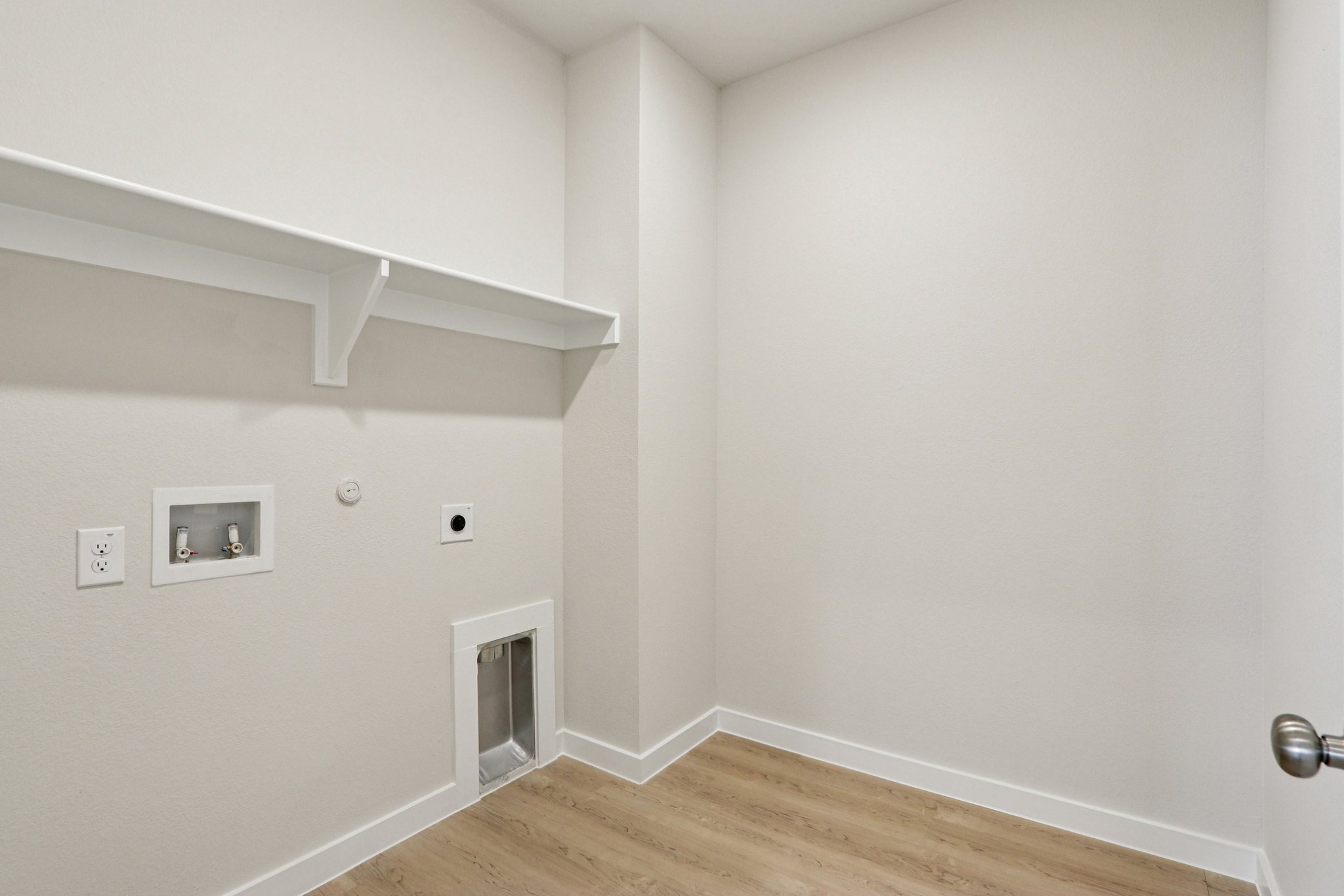 A white room with a wood floor.