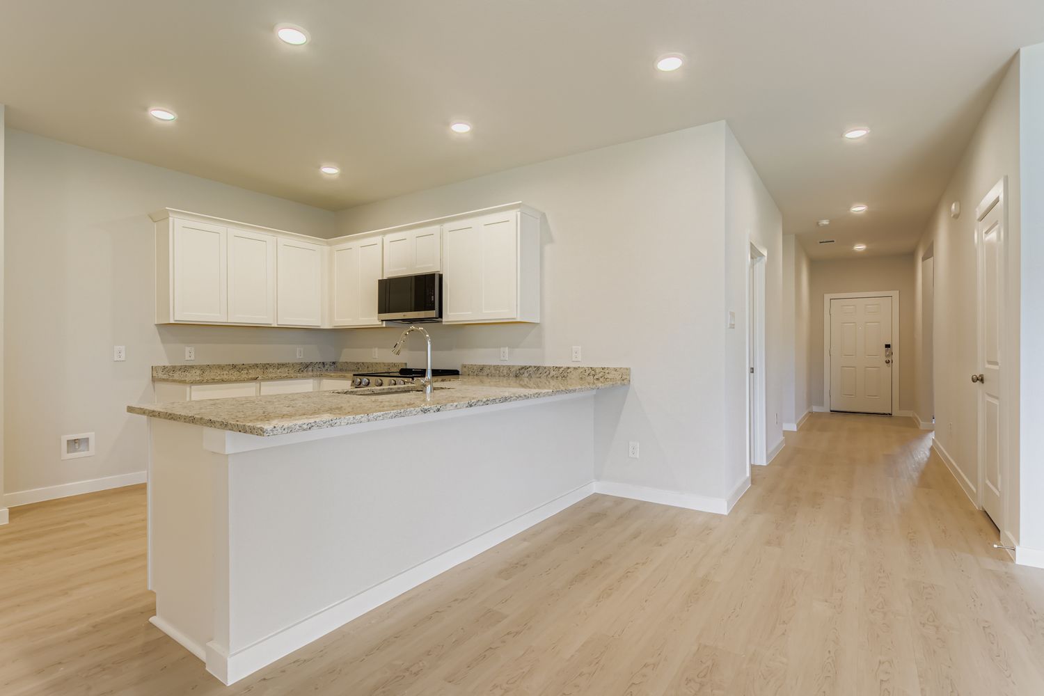 A kitchen with white cabinets.