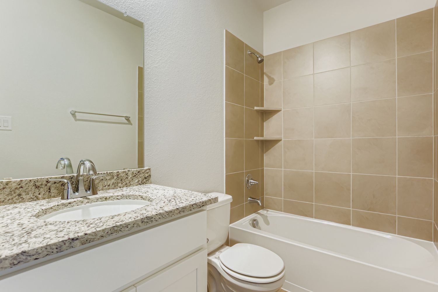 A bathroom with a tub sink and toilet.