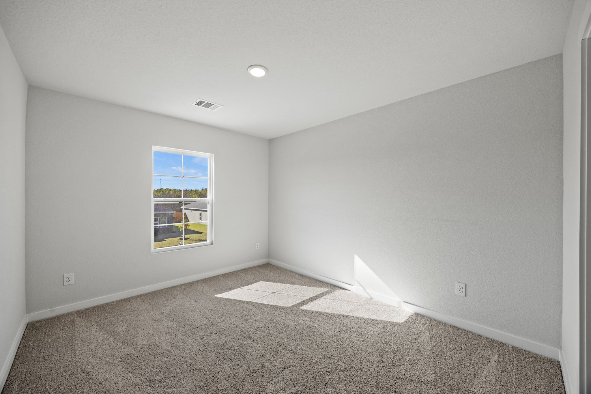 A room with a window and carpet.