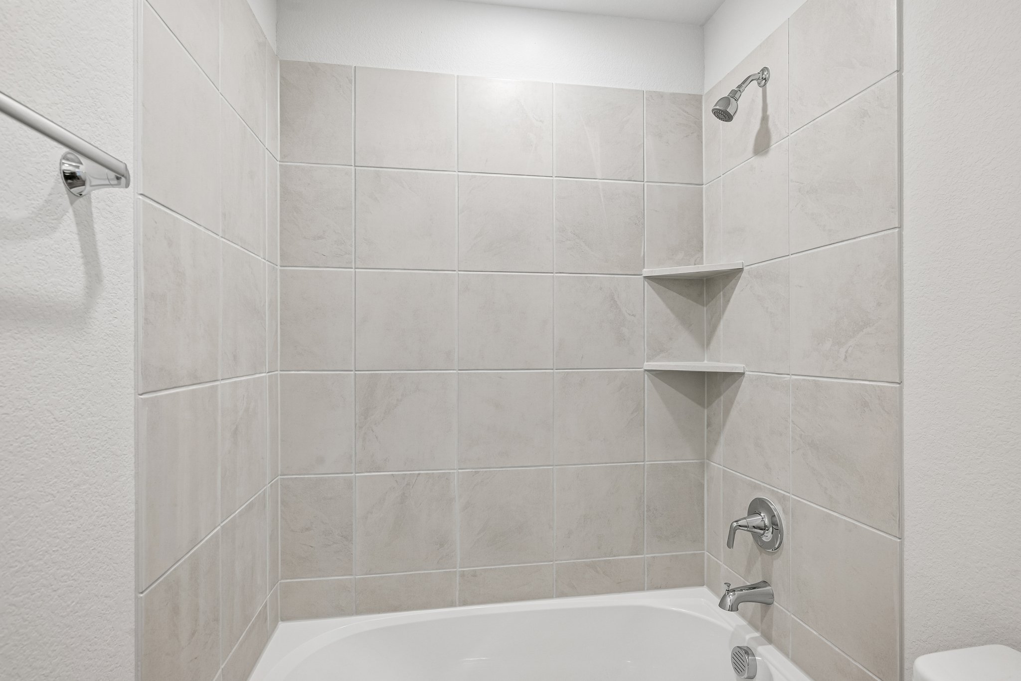 A bathroom with a bathtub and shower unit.
