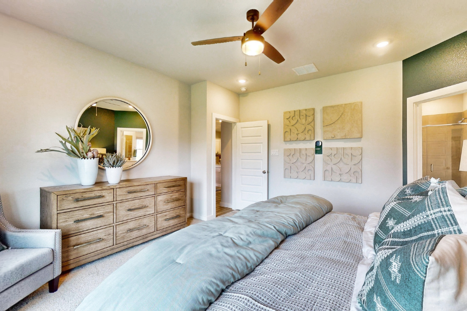 A bedroom with a bed and a fan.