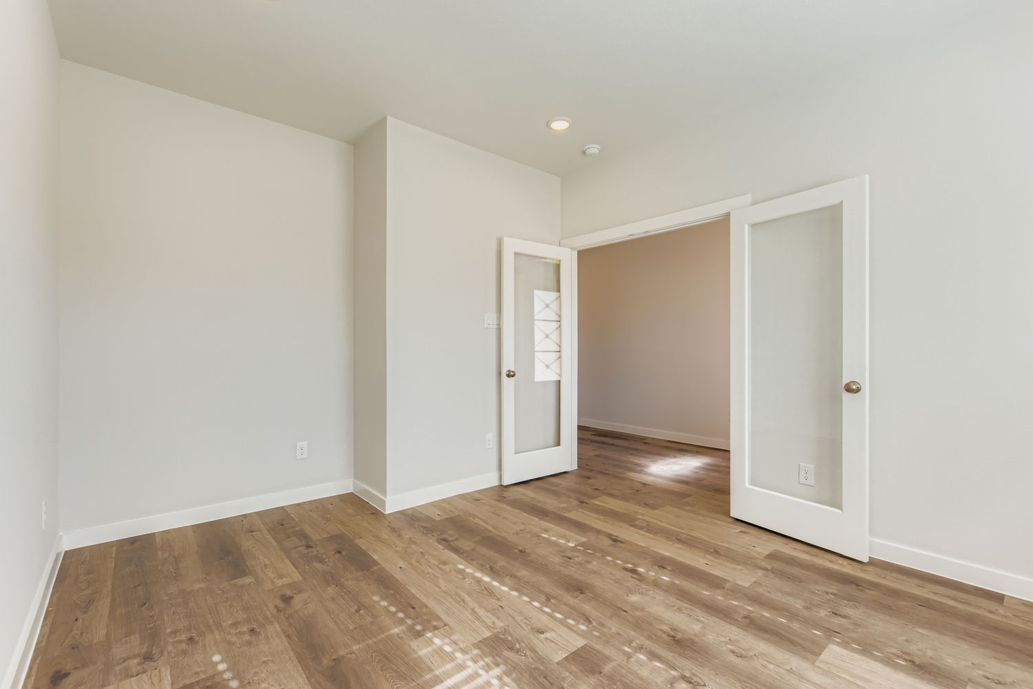 A room with a wood floor and white walls.
