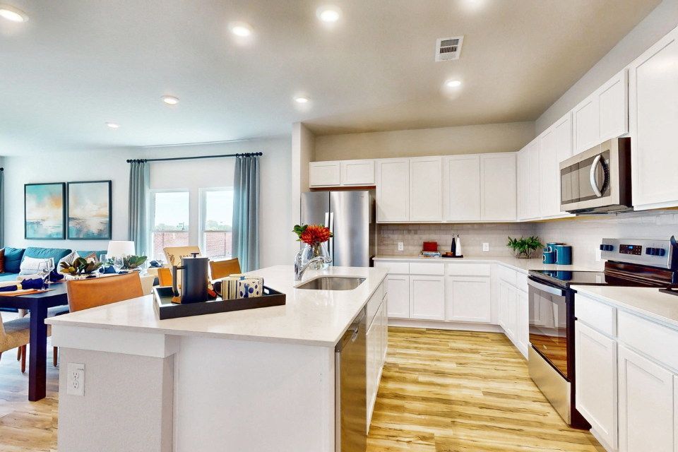 A kitchen with white cabinets.
