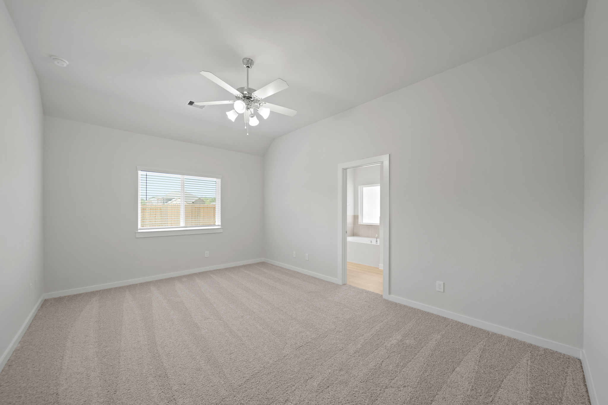 A room with a ceiling fan and a door.