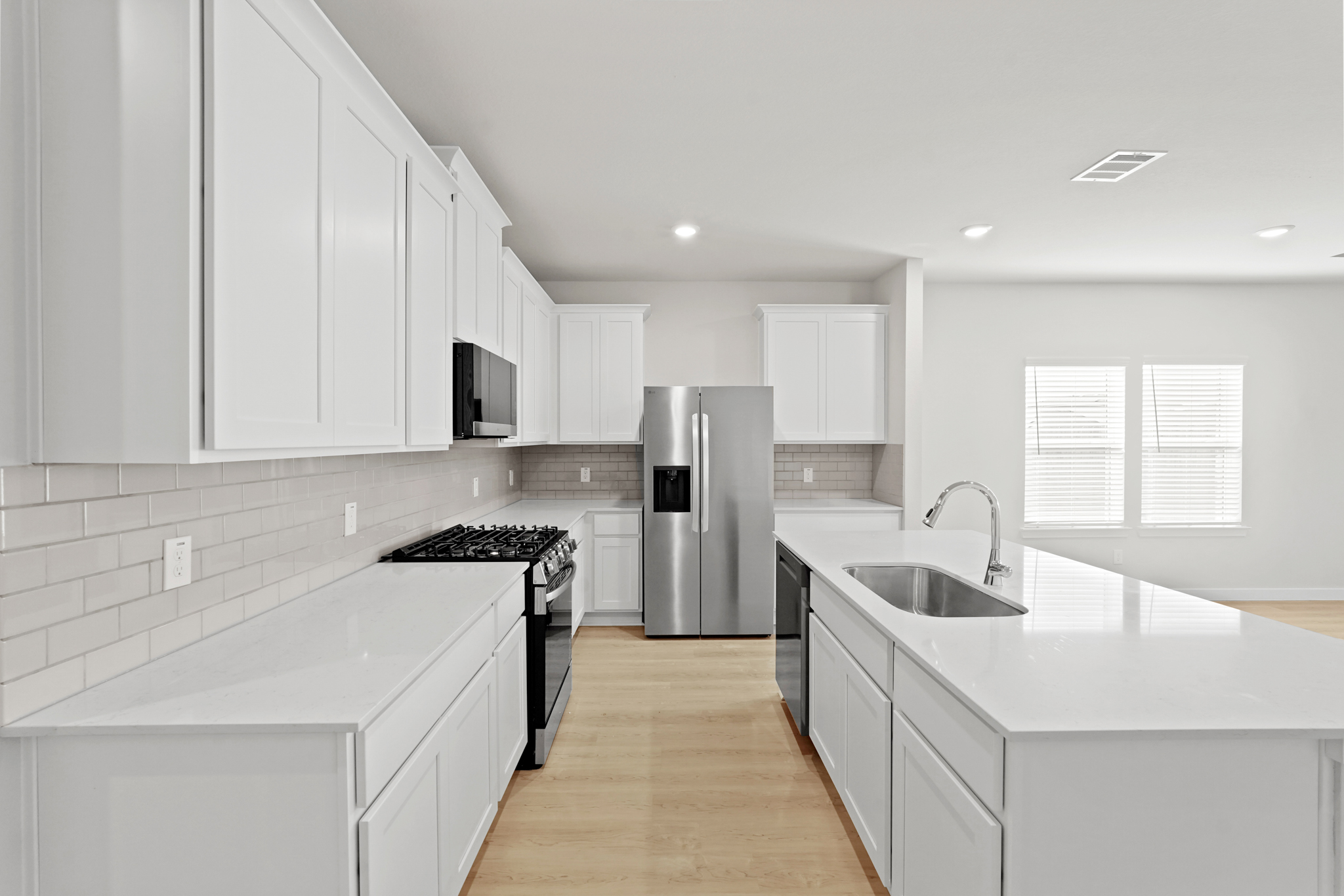 A kitchen with white cabinets.