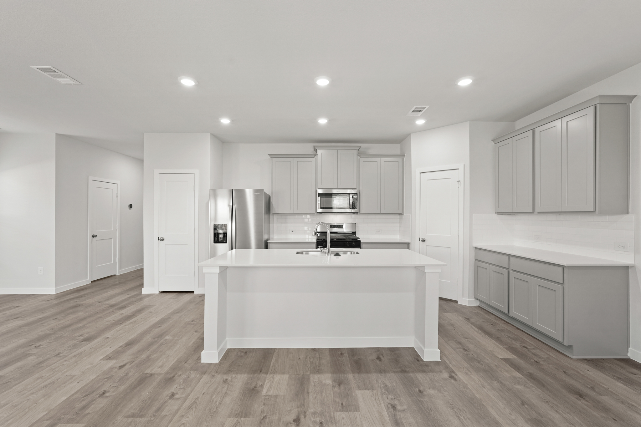 A kitchen with white cabinets.