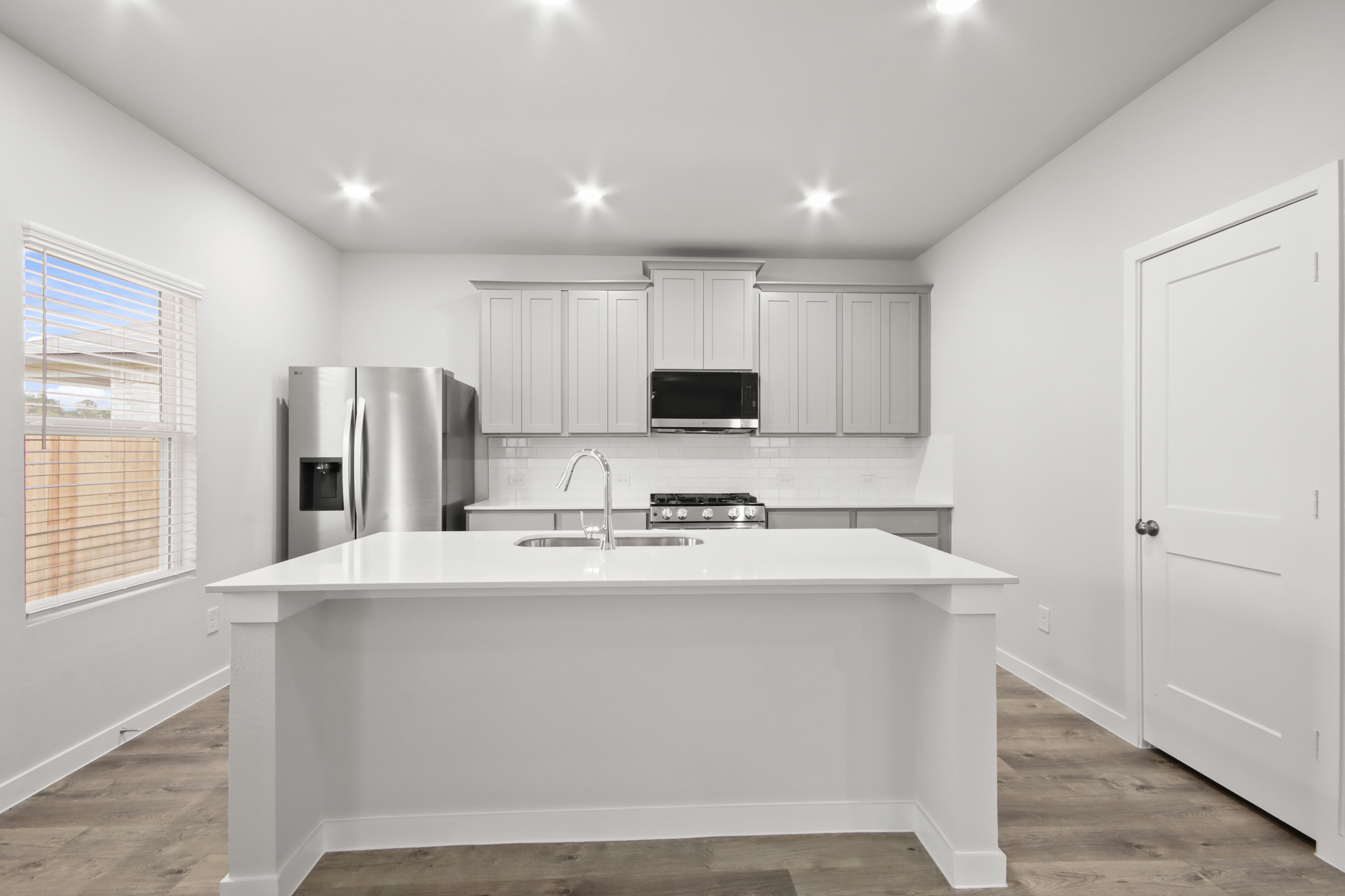 A kitchen with white cabinets.